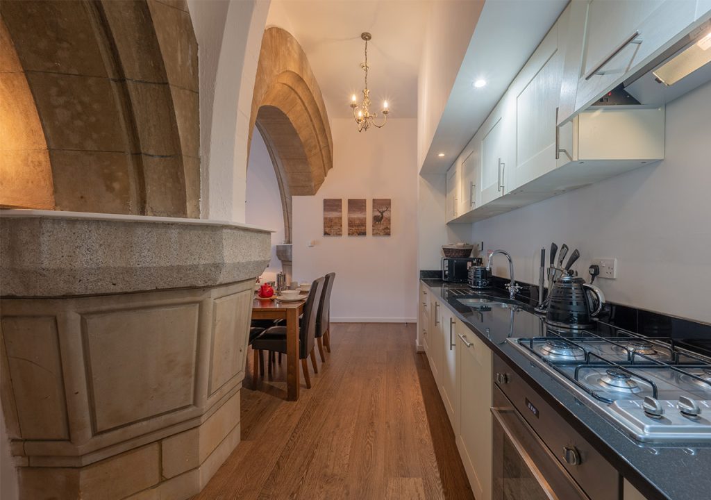 The kitchen and stunning abbey stone archways in Glen Affric accommodation at Abbey Holidays Loch Ness