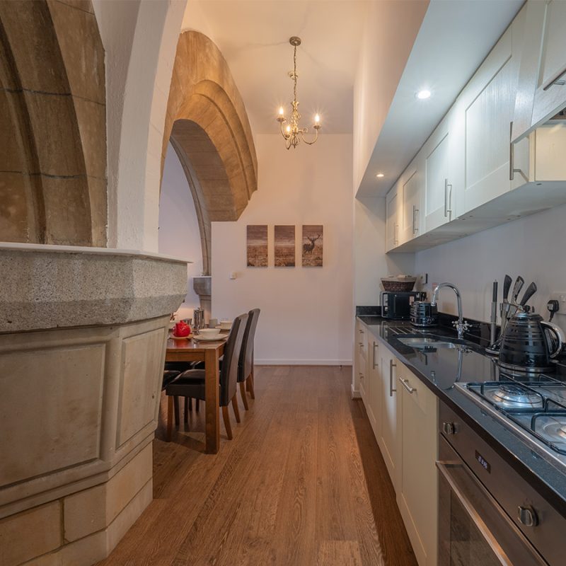 The kitchen and stunning abbey stone archways in Glen Affric accommodation at Abbey Holidays Loch Ness