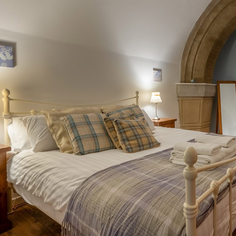 The double bedroom with the spectacular Abbey stone archway in it in the Upper North Aisle at Abbey Holidays Loch Ness