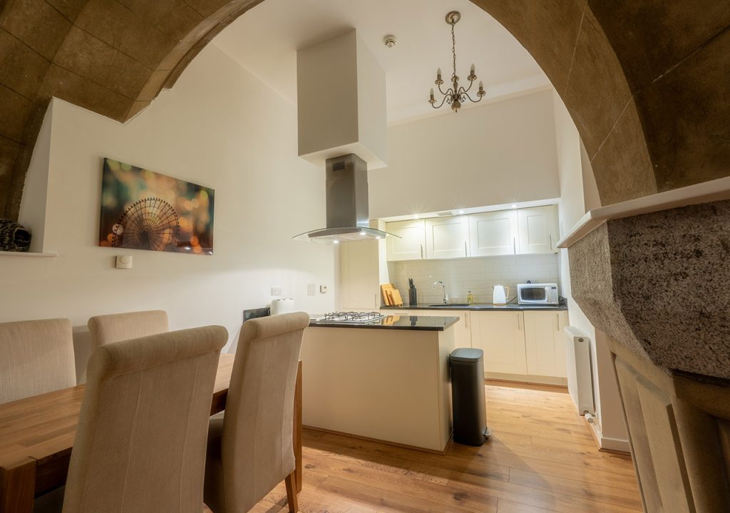 The kitchen and dining with stunning stone archway in The Dunfermline accommodation at Abbey Holidays Loch Ness
