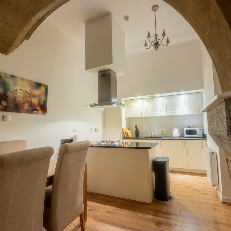 The kitchen and dining with stunning stone archway in The Dunfermline accommodation at Abbey Holidays Loch Ness