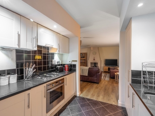 Courtyard Cottage 2 Kitchen The kitchen leading into the living room in the Club Cottage accommodation at Abbey Holidays Loch Ness