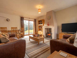 Courtyard Cottage 2 Living Room The living room with cosy fireplace in the Club Cottage accommodation at Abbey Holidays Loch Ness
