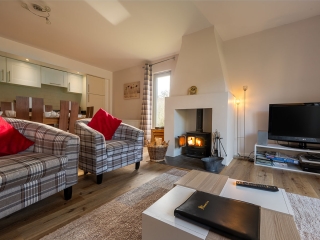Courtyard Cottage 8 Living Room The cosy living room with a log burning stove in Taigh Nan Caorach accommodation at Abbey Holidays Loch Ness