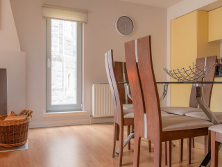 Kitchen Dining Courtyard Cottage 4 The dining and kitchen area with wood burning stove in the Brora accommodation at Abbey Holidays Loch Ness