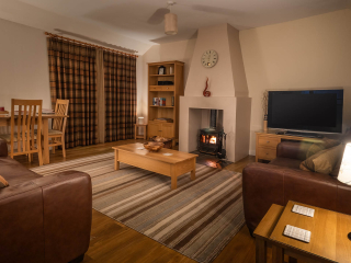 Living Room Courtyard Cottage 2 The living room with cosy fireplace in the Club Cottage accommodation at Abbey Holidays Loch Ness