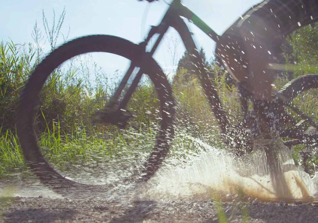 Mountain bike splashing through a puddle