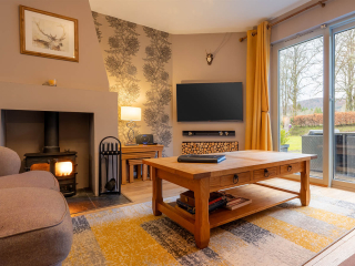Courtyard Cottage 11 Living Room The living room with patio doors onto an outdoor seating area at the Strath Glass accommodation at Abbey Holidays Loch Ness