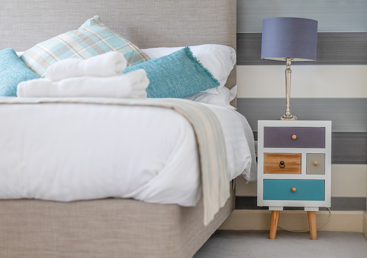 Bed detail and quirky side table in the bedroom in Monastery 10 accommodation at Abbey Holidays Loch Ness