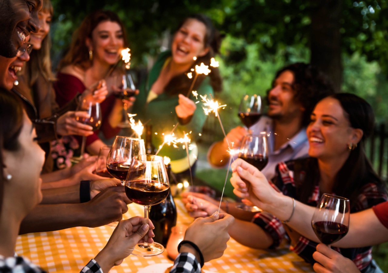 A group of friends on a group holiday dine outdoors by Loch Ness.