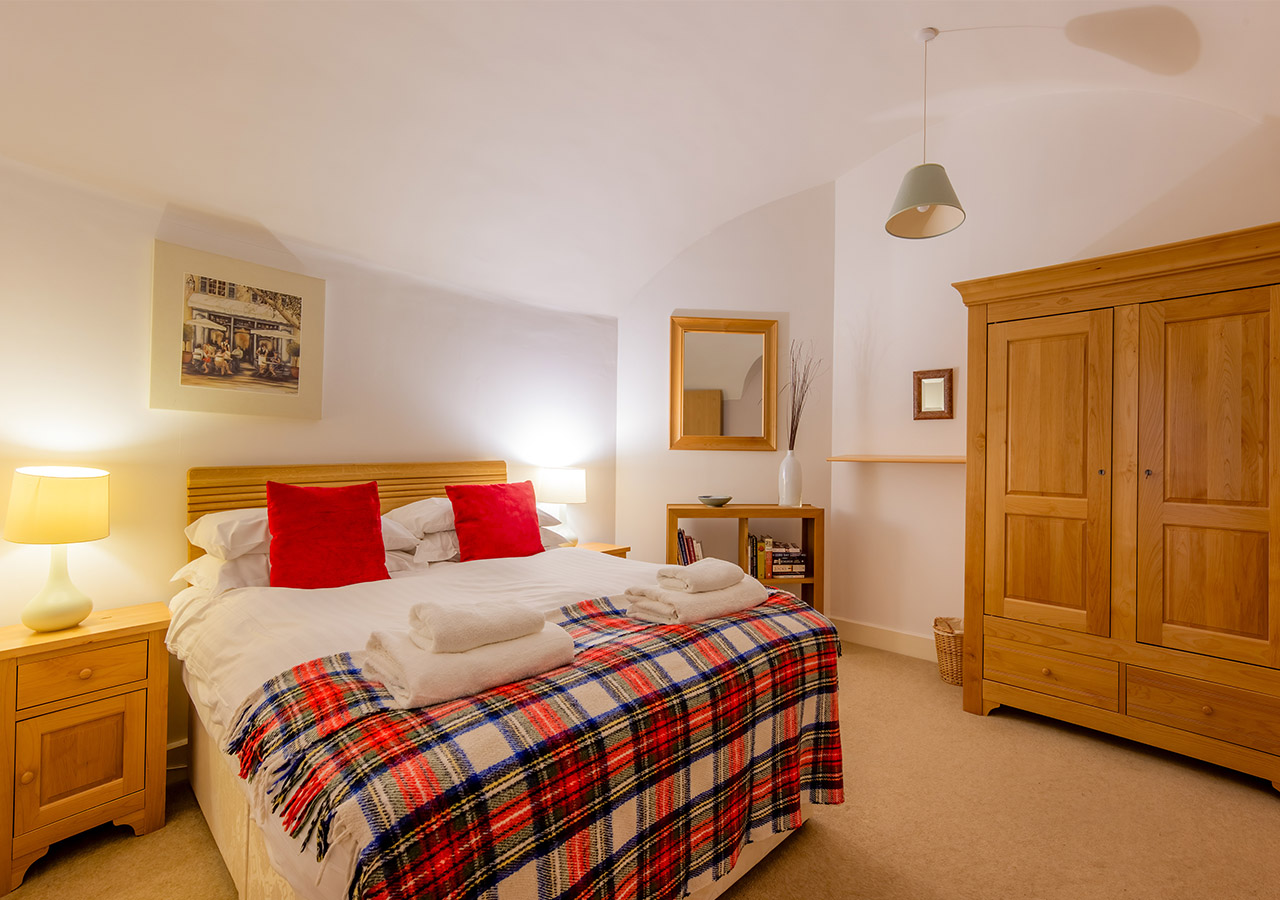 A cosy double bedroom lit up at night in the Major’s Apartment accommodation at Abbey Holidays in Loch Ness