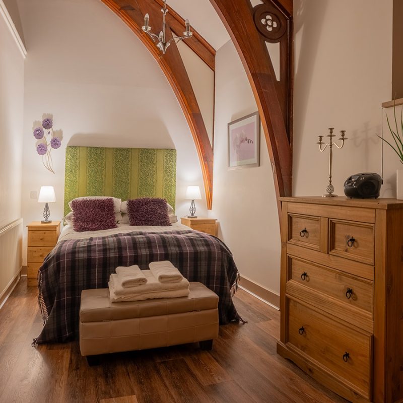 A stunning double room with historic wooden arched beams in The Caledonian accommodation at Abbey Holidays in Loch Ness