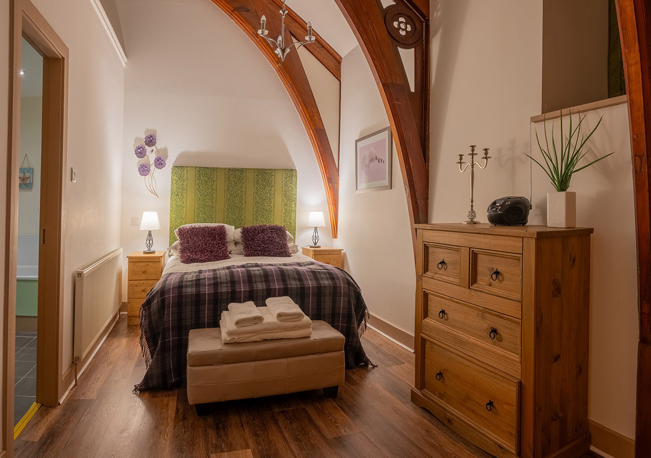 A stunning double room with historic wooden arched beams in The Caledonian accommodation at Abbey Holidays in Loch Ness