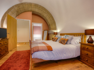Abbey Church 25 - The Dunfermline accommodations double bedroom with stunning stone arch at Abbey Holidays by Loch Ness
