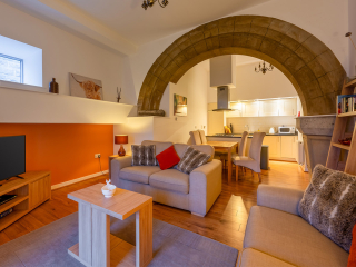 Abbey Church 25 - The Dunfermline accommodations living room, kitchen and dining room with stunning stone arch at Abbey Holidays by Loch Ness