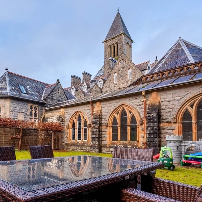The exterior with garden and garden furniture at Abbey Church 9 -The Nave accommodation at Abbey Holidays Loch Ness