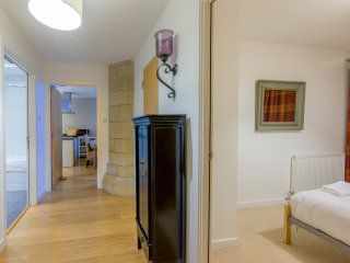 Abbey Church 9 The Nave hallway with bathroom, open plan living and bedroom off of it at Abbey Holidays by Loch Ness
