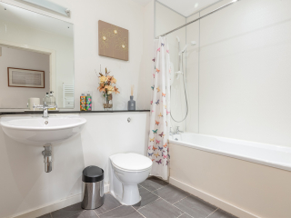 Courtyard Cottage 2 Club Cottage bathroom with shower over bath at Abbey Holidays by Loch Ness
