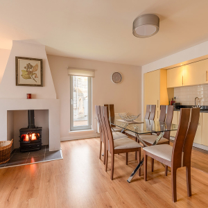 Courtyard Cottage 4 - Brora accomodation&#039;s dining and kitchen with burning stove at Abbey Holidays Loch Ness