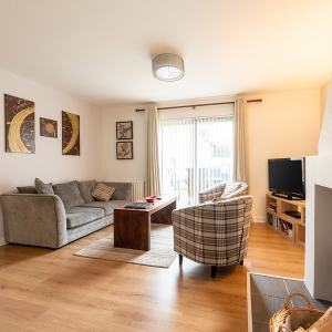 Courtyard Cottage 4 - Brora accomodation&#039;s living and dining room with a burning stove at Abbey Holidays Loch Ness