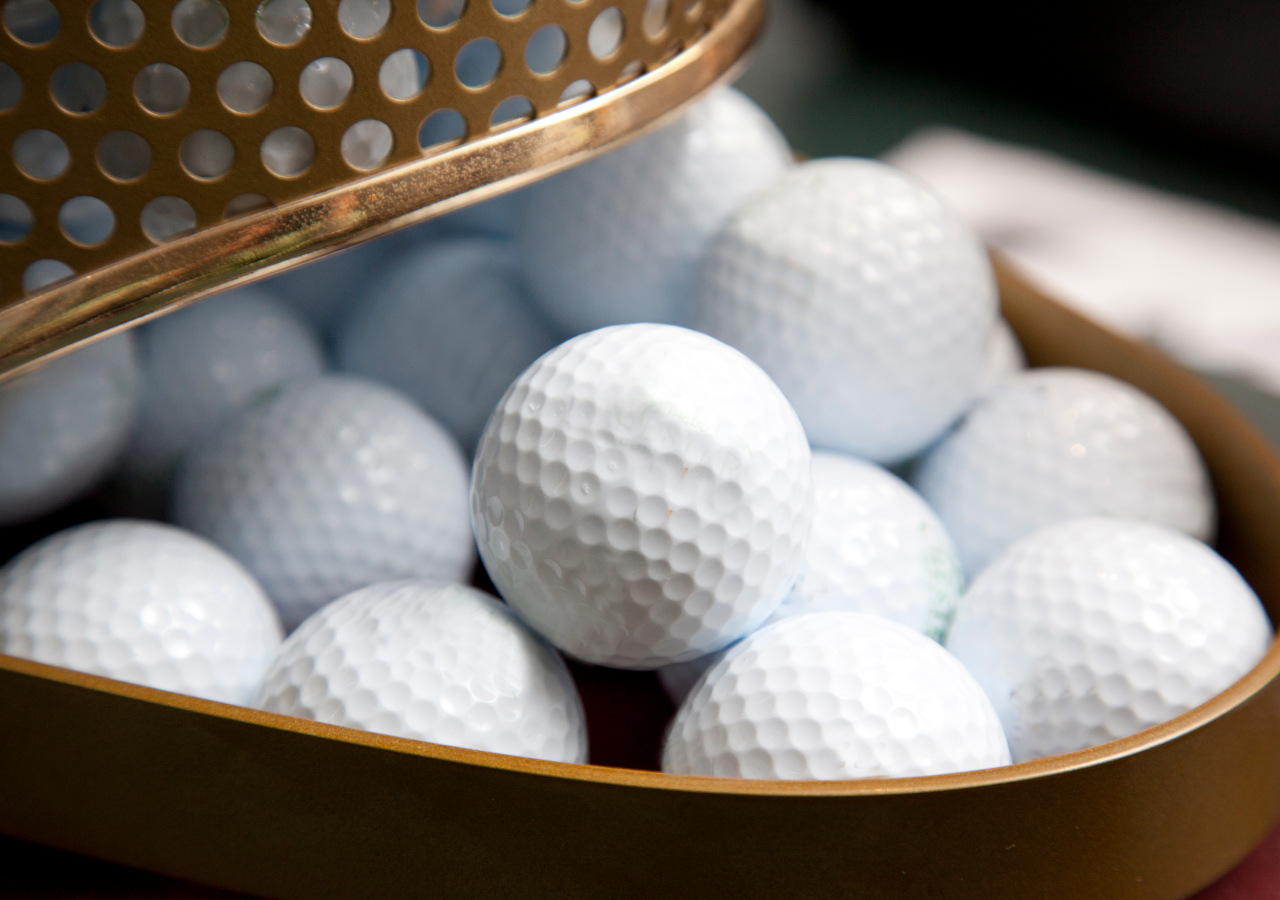 Container filled with white golf balls