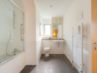 Courtyard Cottage 11 - Strath Glass accommodation&#039;s bathroom with shower over bath at Abbey Holidays Loch Ness