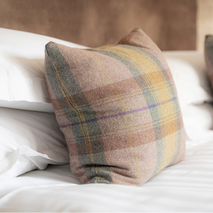 Strath Glass accommodation&#039;s cushion detail on bed at Abbey Holidays Loch Ness