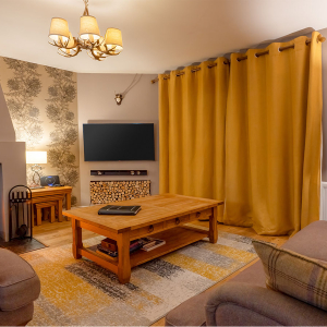 Strath Glass accommodation&#039;s living room with burning stove at Abbey Holidays Loch Ness