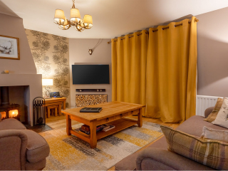 Strath Glass accommodation&#039;s living room with burning stove at Abbey Holidays Loch Ness