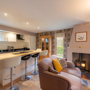 Strath Glass accommodation&#039;s open plan living with burning stove at Abbey Holidays Loch Ness