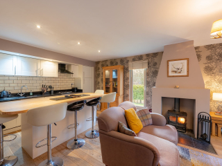 Strath Glass accommodation&#039;s open plan living with burning stove at Abbey Holidays Loch Ness