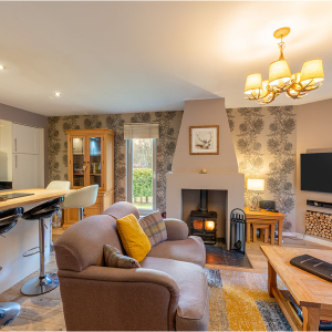 Strath Glass accommodation&#039;s open plan living with burning stove at Abbey Holidays Loch Ness