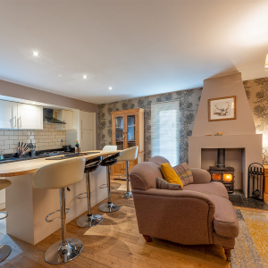 Strath Glass accommodation&#039;s open plan living with burning stove at Abbey Holidays Loch Ness