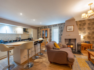 Strath Glass accommodation&#039;s open plan living with burning stove at Abbey Holidays Loch Ness