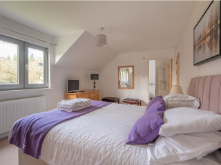 Courtyard Cottage 8 - Taigh Nan Caorach accommodation&#039;s double bedroom with en-suite at Abbey Holidays Loch Ness