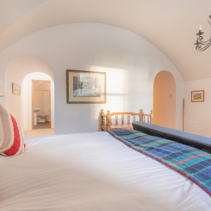 Moat House 2 - Major&#039;s Apartment accommodation&#039;s double bedroom with arched wall at Abbey Hoildays Loch Ness
