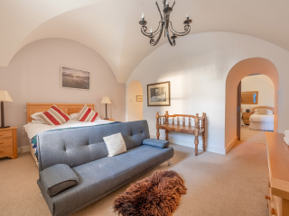 Moat House 2 - Major&#039;s Apartment accommodation&#039;s double bedroom with arched wall at Abbey Hoildays Loch Ness