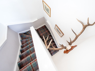 Moat House 2 - Major&#039;s Apartment accommodation&#039;s stariwell with deer antlers on the wall at Abbey Hoildays Loch Ness