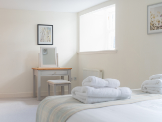 Monastery 10 - Brunel accommodation&#039;s double bedroom and dressing table at Abbey Holidays Loch Ness