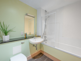 The Caledonian - Old School 12 accommodation&#039;s bathroom with shower over the bath at Abbey Holidays Loch Ness