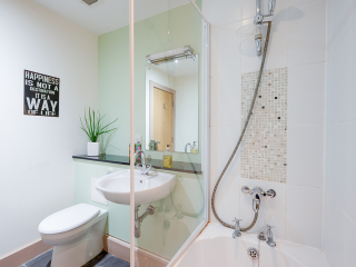 The Caledonian - Old School 12 accommodation&#039;s bathroom with shower over the bath at Abbey Holidays Loch Ness