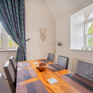 The Caledonian - Old School 12 accommodation&#039;s dining area with arched windows at Abbey Holidays Loch Ness