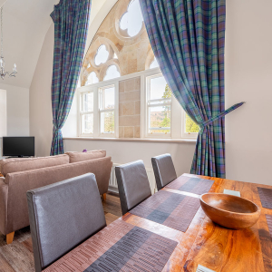 The Caledonian - Old School 12 accommodation&#039;s open plan living area with stunning arched, ornate and decorative windows at Abbey Holidays Loch Ness