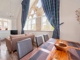 The Caledonian - Old School 12 accommodation&#039;s open plan living area with stunning arched, ornate and decorative windows at Abbey Holidays Loch Ness