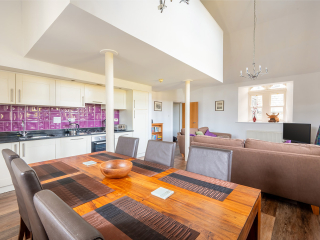 The Caledonian - Old School 12 accommodation&#039;s open plan living area with mezzanine housing the double bedroom at Abbey Holidays Loch Ness