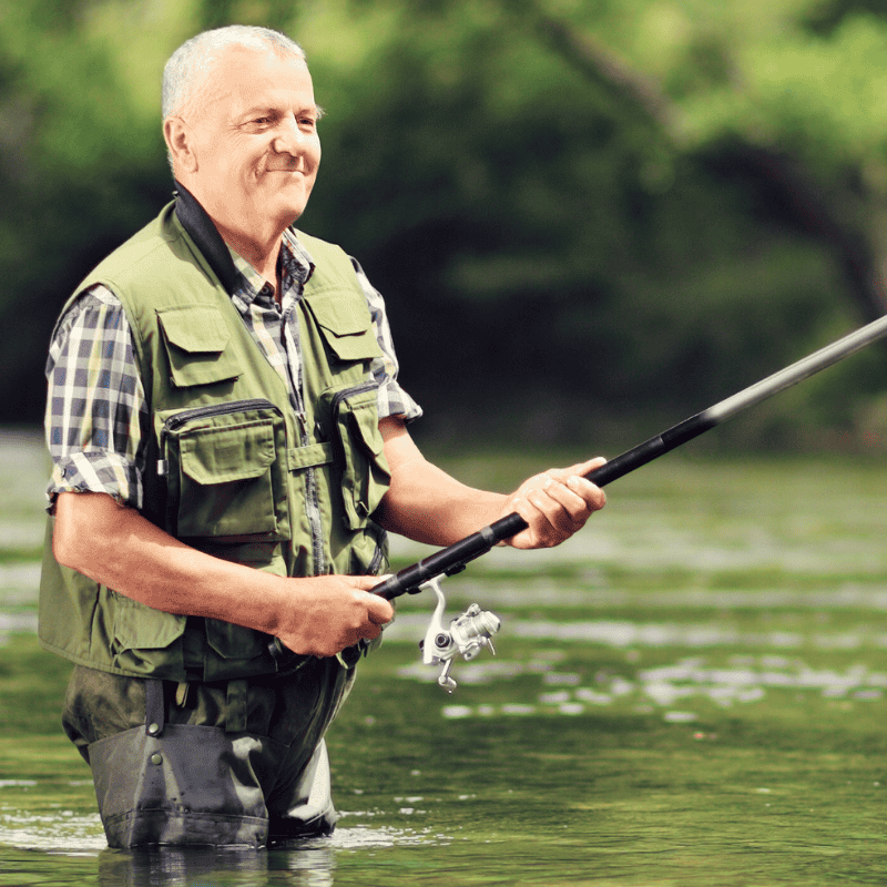 A fisherman in the river with his rod.